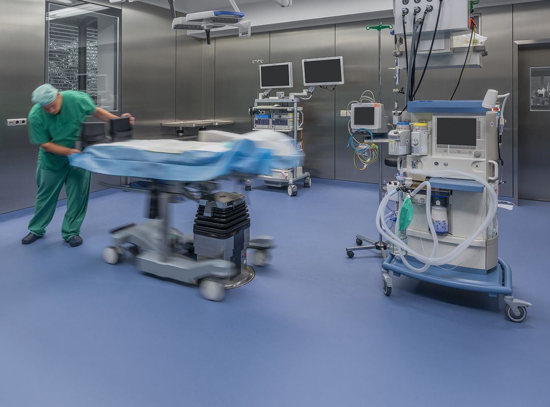 Operationstisch in Bewegung in einem Krankenhaus-Reinraum mit hygienischer Bodenbeschichtung