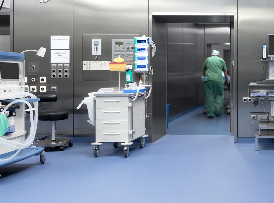 Hygienischer, blauer Bodenbelag in einem Krankenhaus, in dem verschiedene Geräte stehen